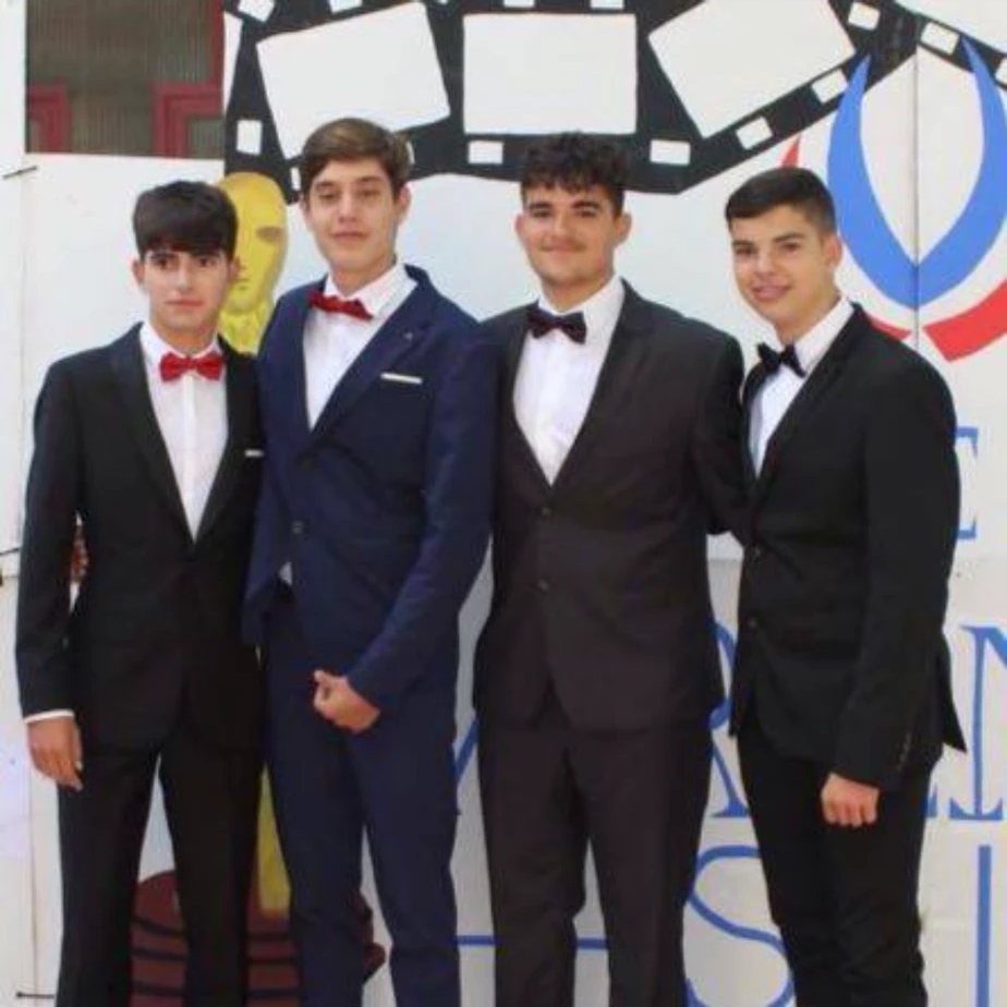 Alejandro con tres amigos, de traje y pajarita